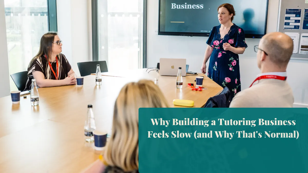 Sarah Capewell standing beside a whiteboard, speaking to a group of tutors at a strategy day.