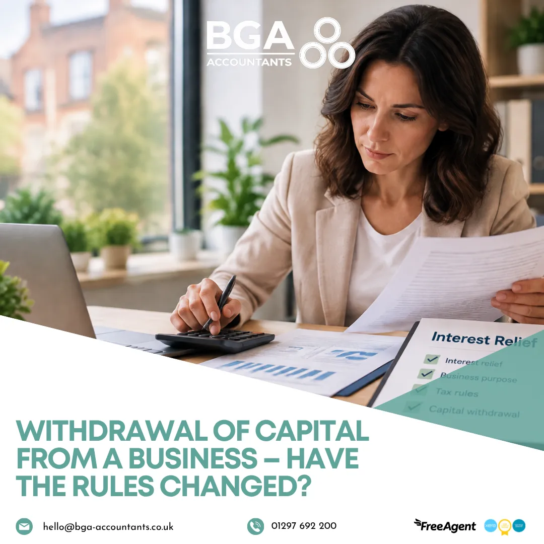 Business owner reviewing financial documents and calculating figures while learning about changes to capital withdrawal and interest relief rules.