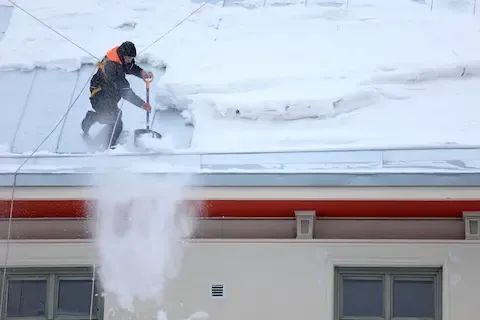 Roof snow removal with shovel and safety gear | Brooklyn Park Lawn & Snow roof clearing service