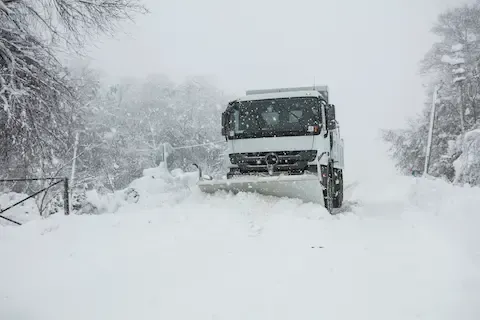 Commercial snowplow clearing packed snow | Brooklyn Park Lawn & Snow commercial snow plowing