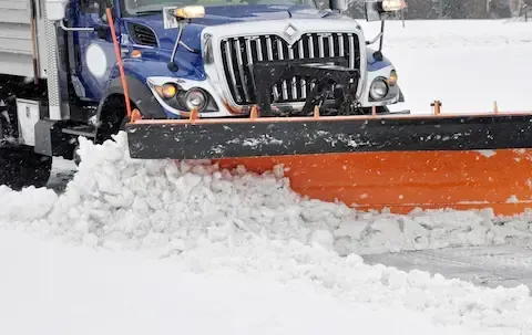 Commercial snowplow clearing packed snow | Brooklyn Park Lawn & Snow commercial snow plowing