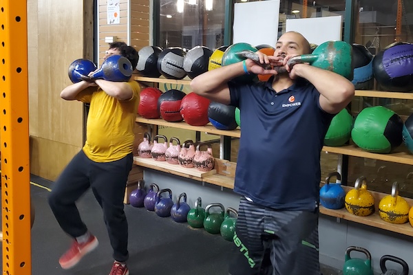 Coach Leon with an athlete and kettlebells