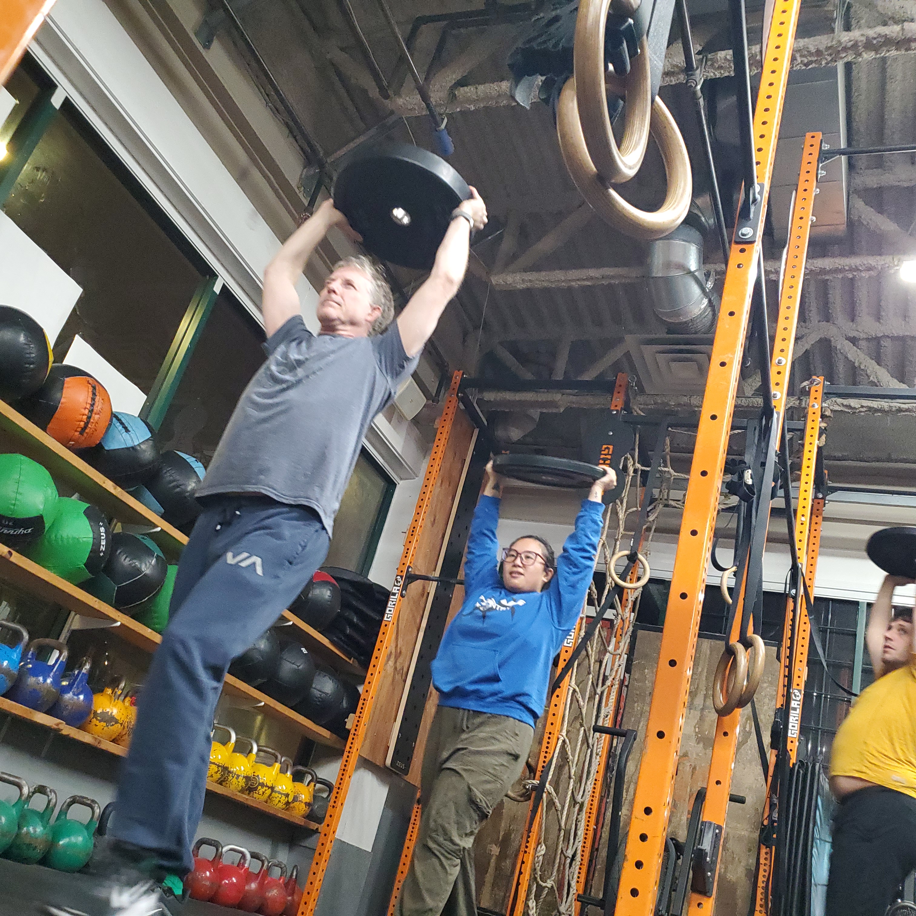 Overhead plate carry during Fight Fit at Empower in Vancouver