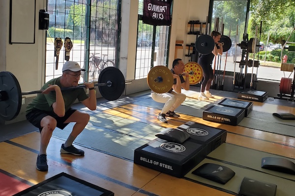 Coach Leon with an athlete and kettlebells