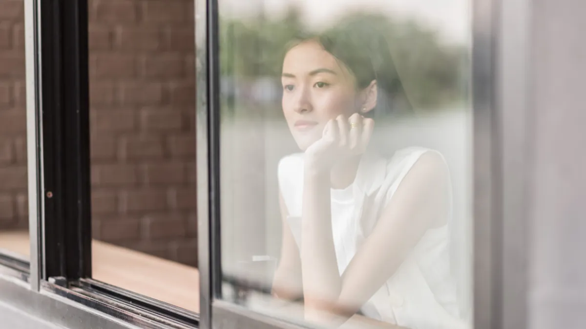 Woman looking out the window, contemplating