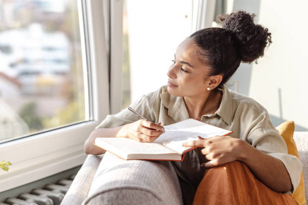 Woman looking hopeful and writing in her notebook