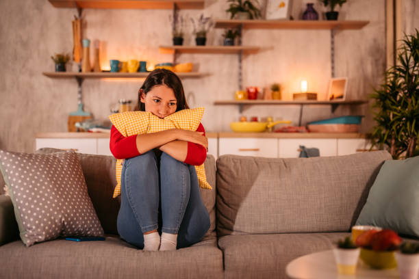 Woman sitting on the couch, looking tired.