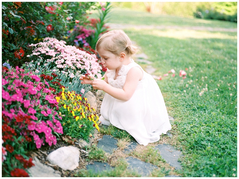Little girl smelling flowers outdoors at Jimmy Neal Park in Jonesborough TN