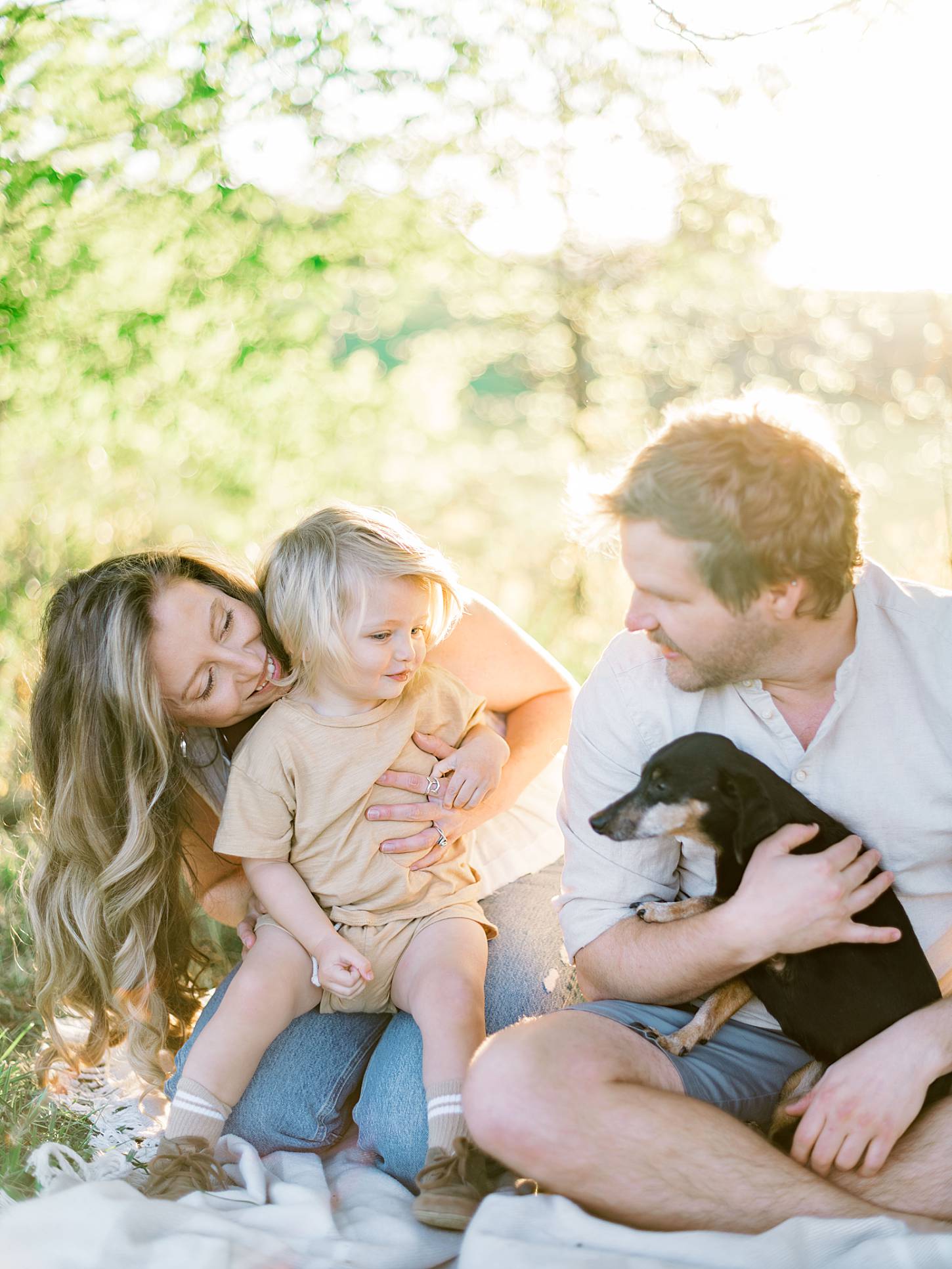 Family holding dog together in scenic East Tennessee mountain landscape