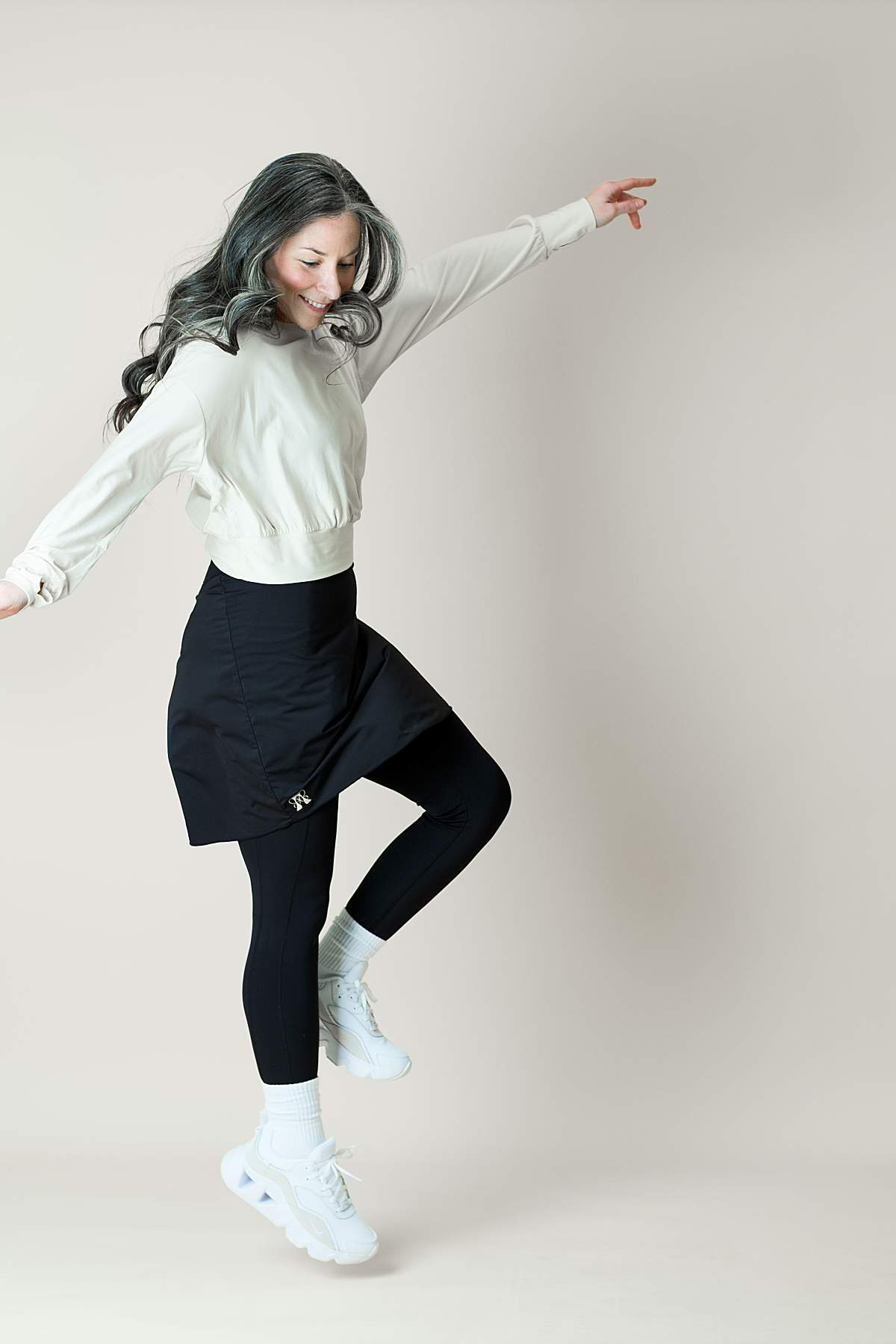 Athletic women jumping in the air wearing modest athletic apparel