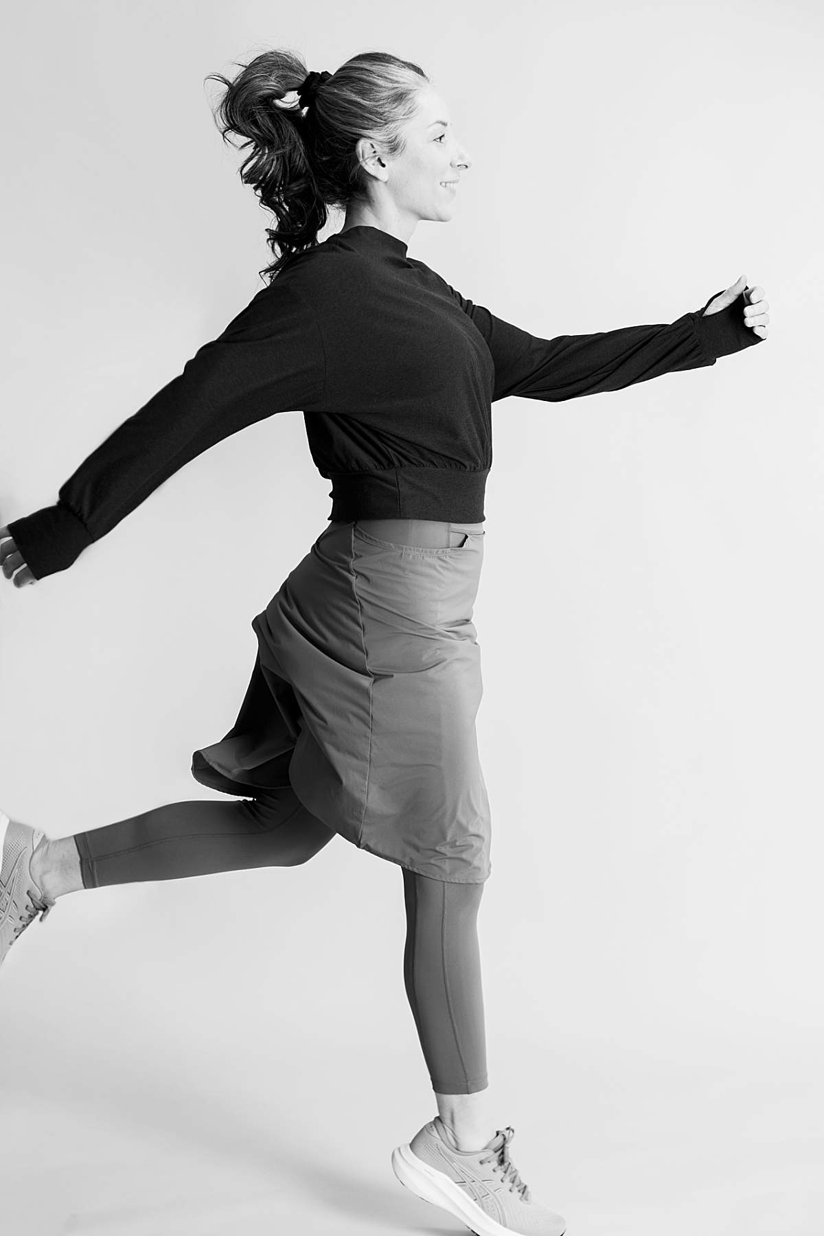 Modest athlete wearing skirted leggings while jumping in the air