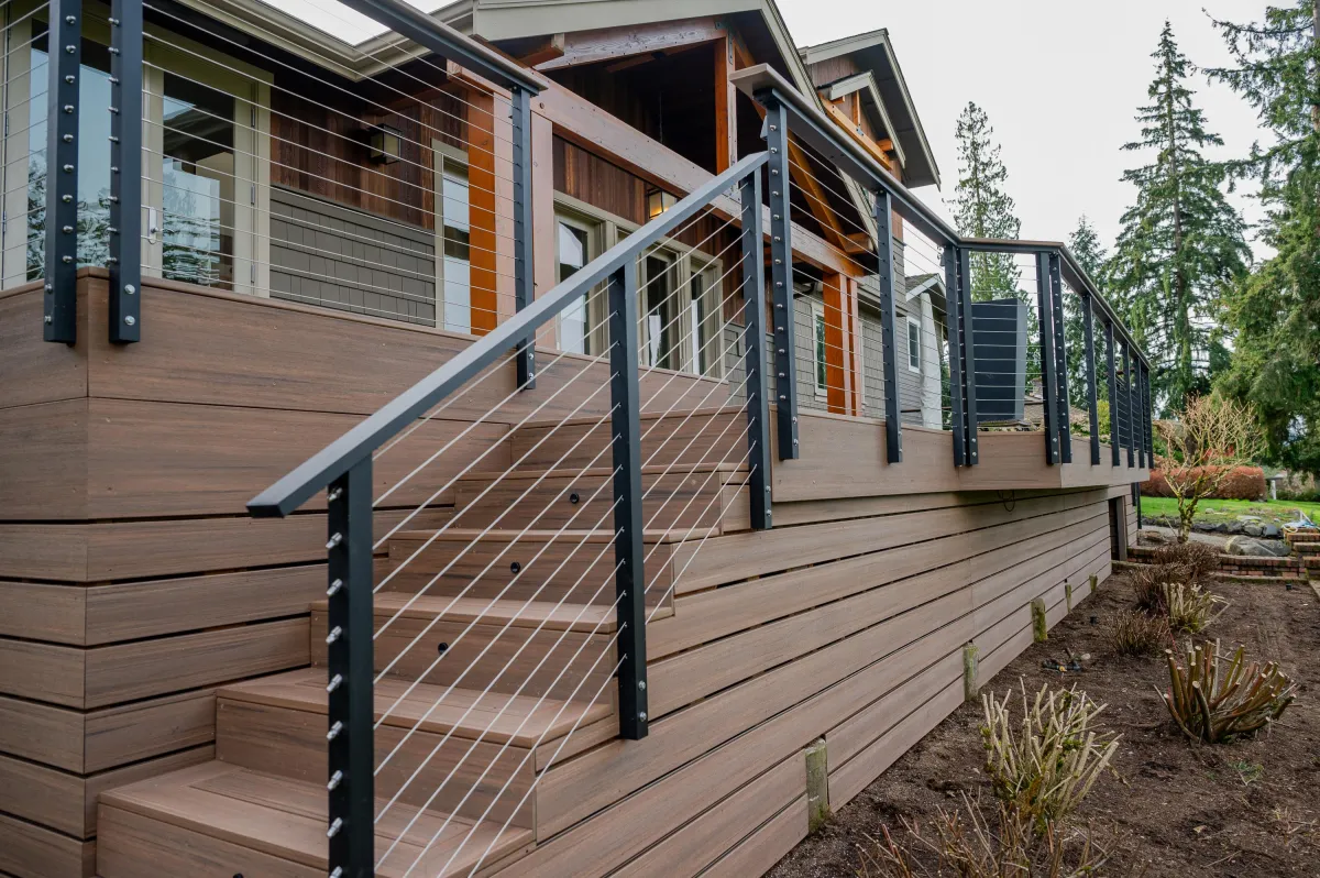 Renovated wooden deck with sleek metal and wood railing in golden hour light