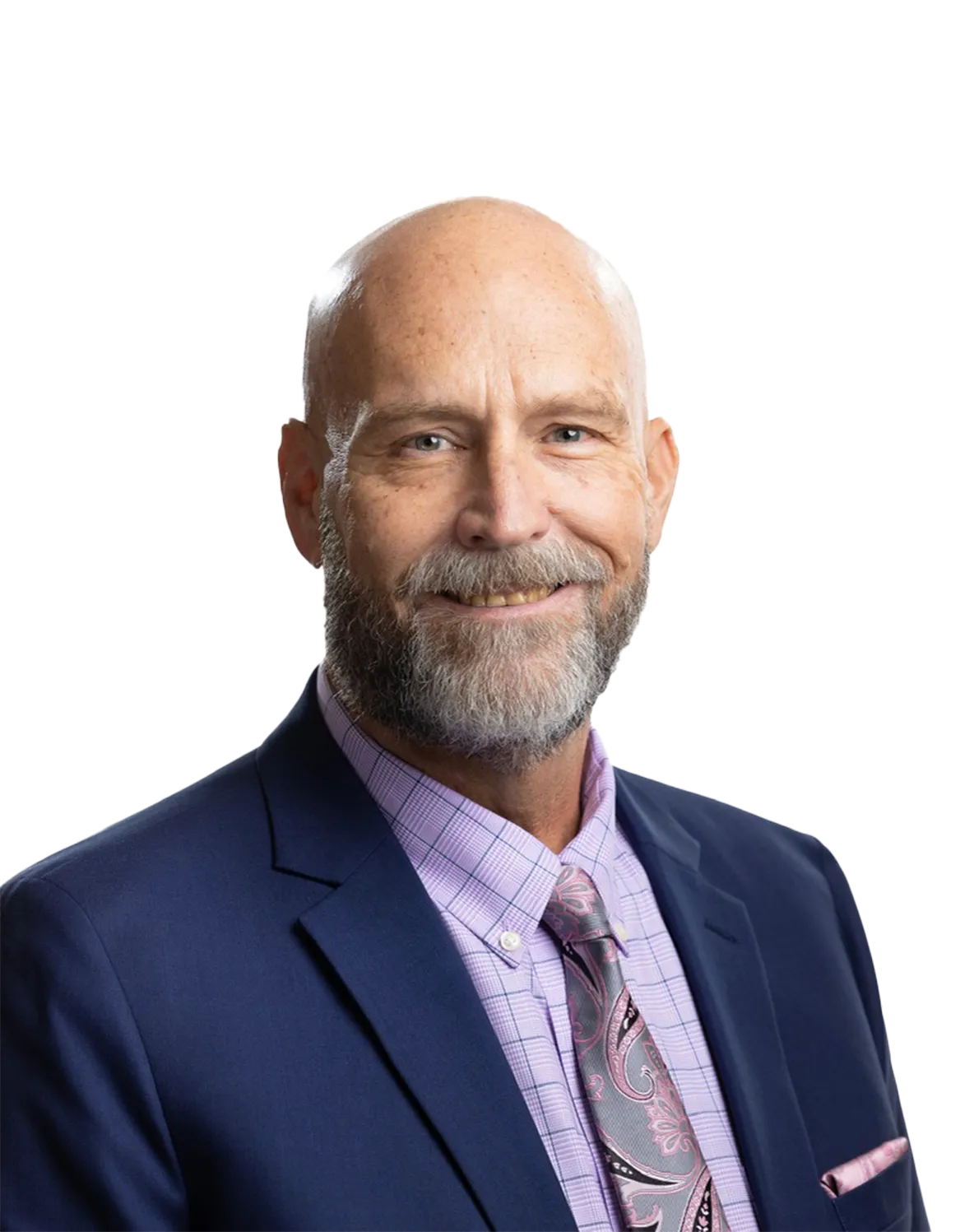 The photo is a professional portrait of Matt Kallunki. He is depicted from the chest up, wearing a smart dark blue suit with a light purple checkered shirt and a matching paisley-patterned tie. Matt has a clean-shaven head, a well-groomed beard, and a warm, welcoming smile. His expression conveys confidence and approachability. The background is a simple, subtle gradient that does not distract from his engaging demeanor. This image is ideal for representing a professional yet personable image on business websites and social media profiles.