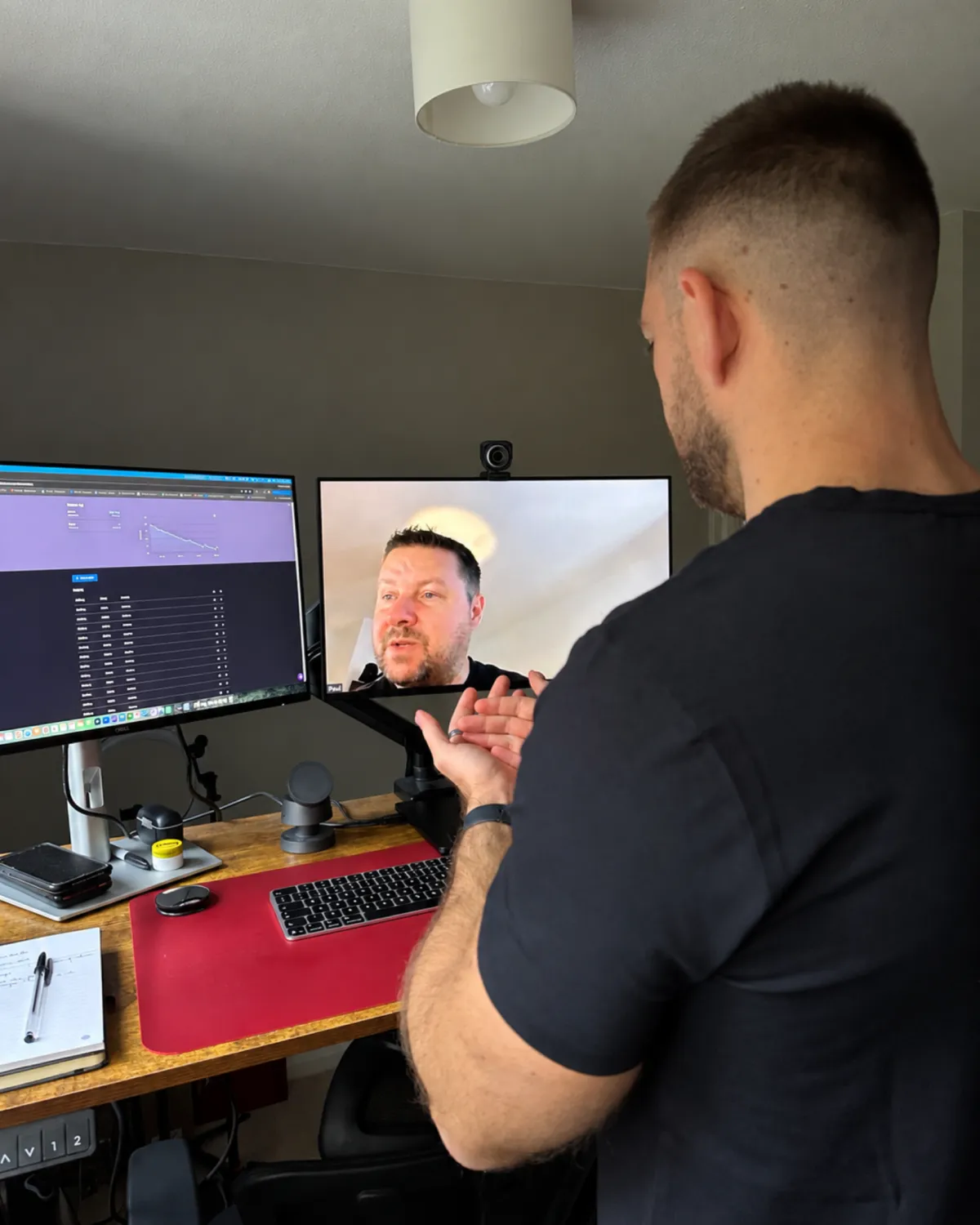 Coach analyzing performance data on a tablet with a client in a minimalist gym setting