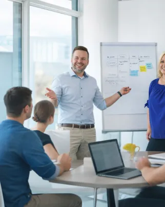A professional leadership keynote speaker presenting to an engaged audience at a corporate workshop featuring interactive roundtable discussions.