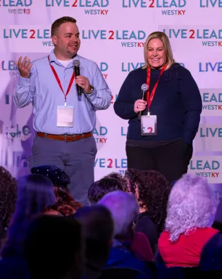 Fulcra Leadership Group founders speaking on stage at the Live2Lead West KY event, delivering high-energy leadership inspiration to a local audience.