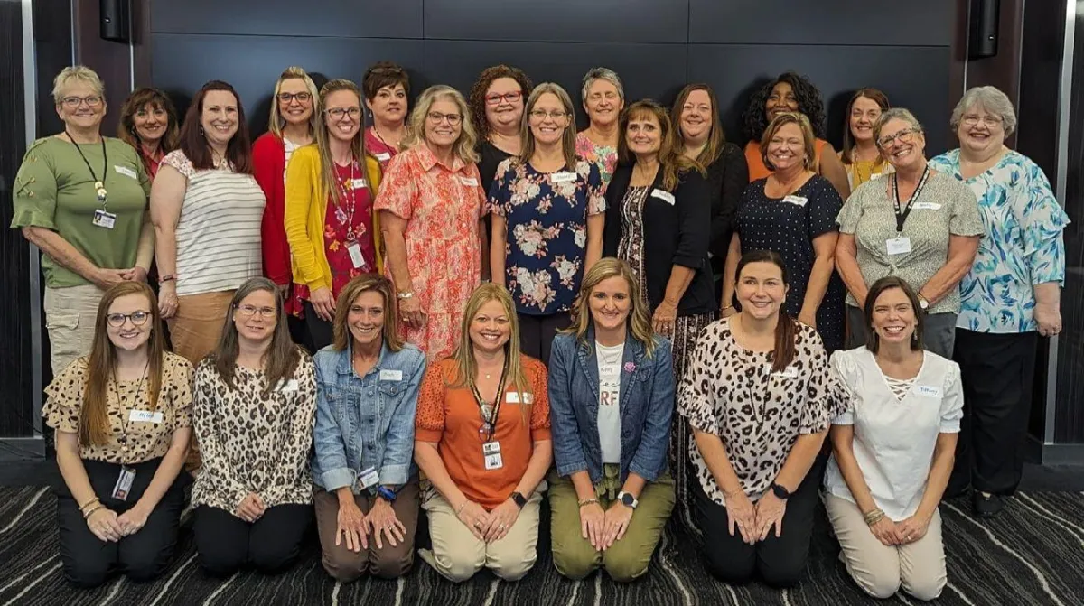 A large group of professional women posing together at a Fulcra leadership development and team alignment event.