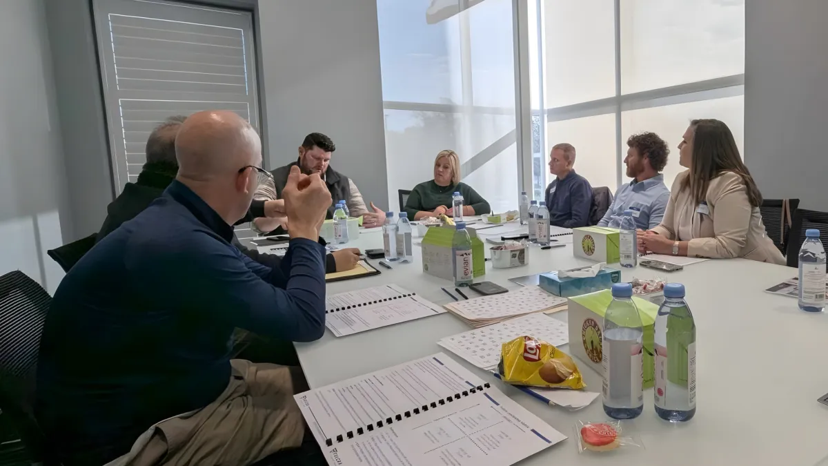 Nathan Carter facilitating an interactive team training session with whiteboards and strategic planning tools in a bright, modern office.
