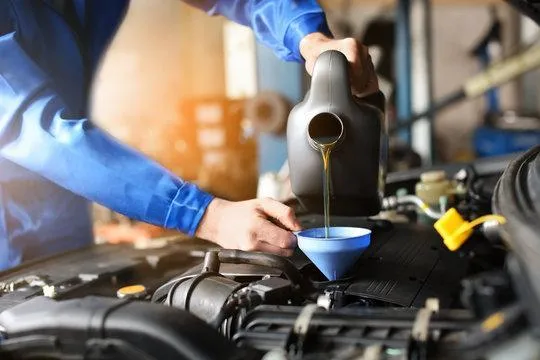 mechanic performing general maintenance of oil and filter change on a vehicle