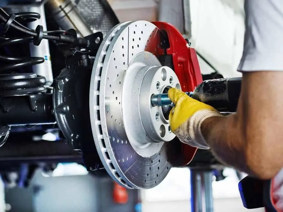 auto service mechanic inspecting brakes and rotors to replacement