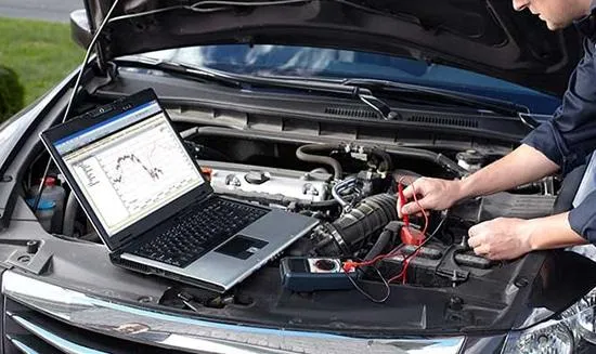 Mechanic diagnosing a car that has a check engine light with his computer