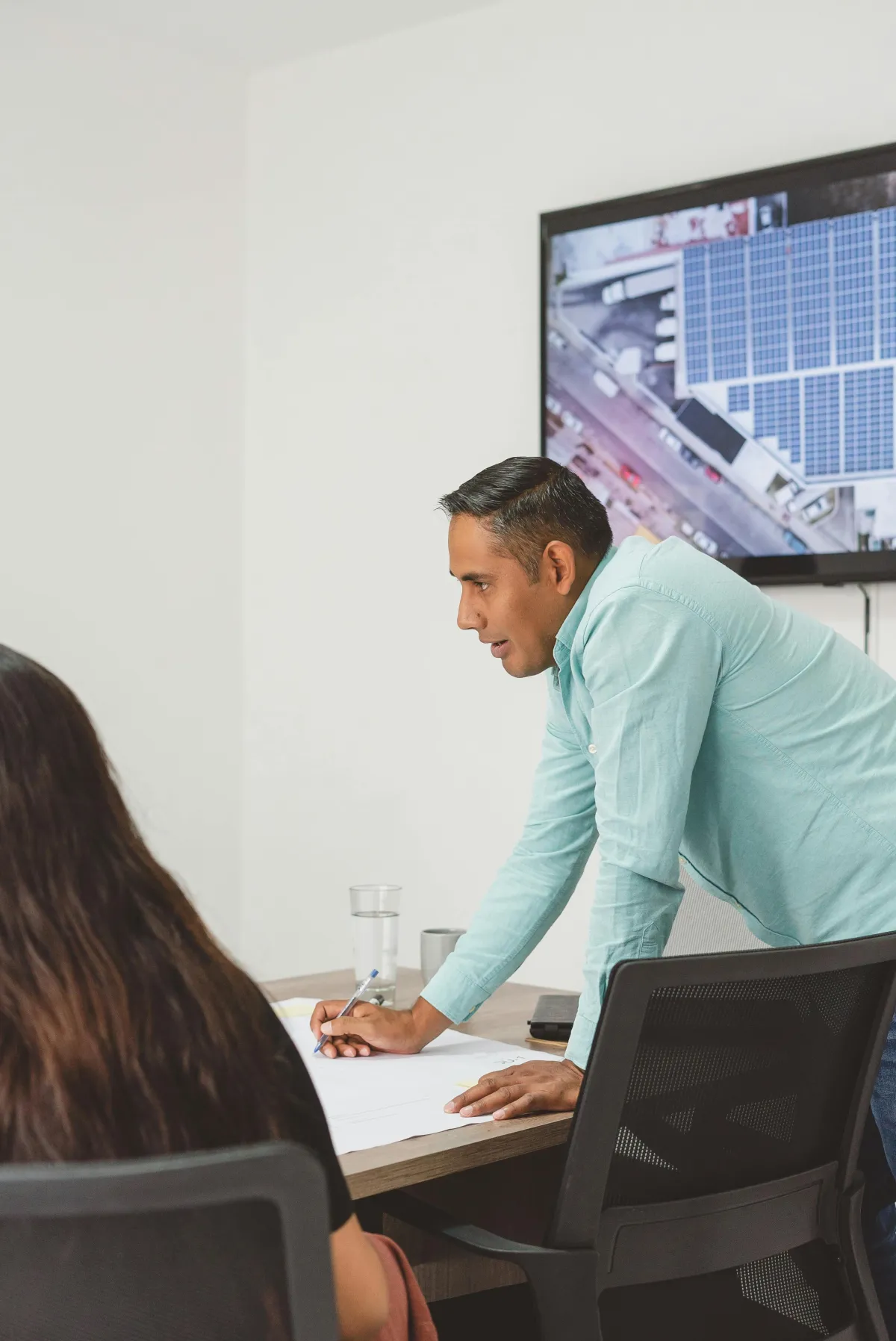 two women writing on glass panel