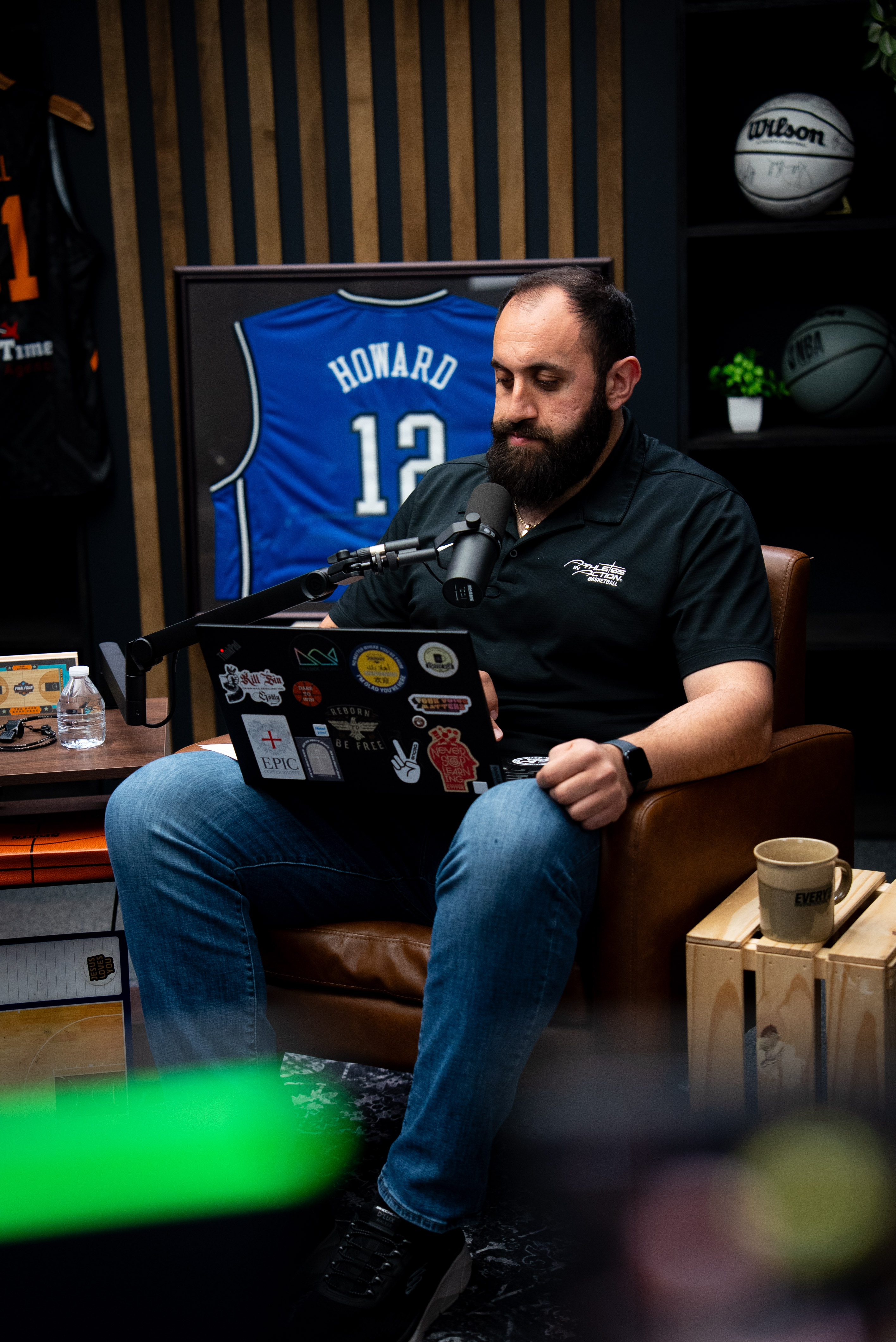 Podcast host gesturing during a recorded conversation in a professional studio — short-form video clip moment