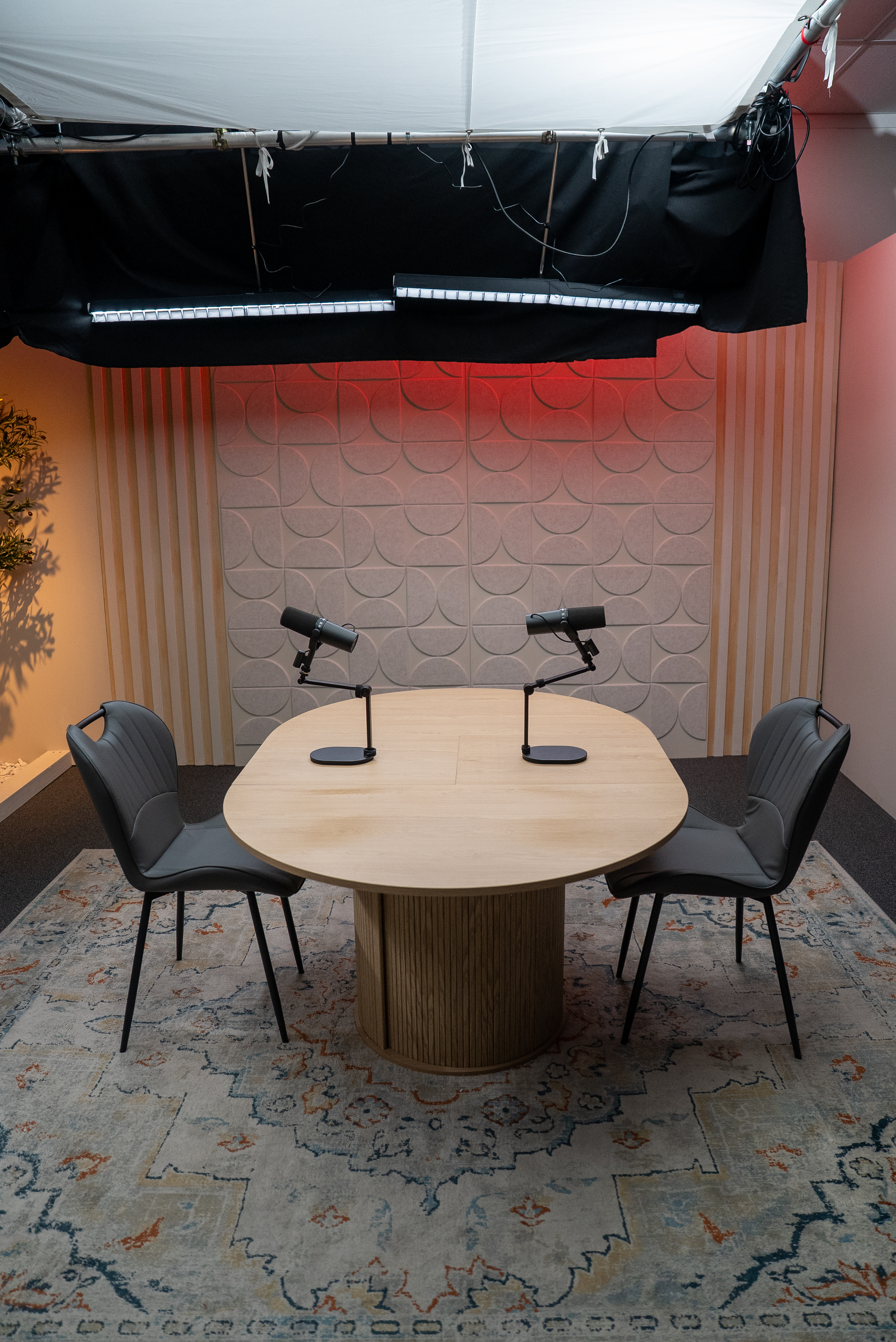 Empty studio set with round table and professional overhead lighting ready for a video recording session