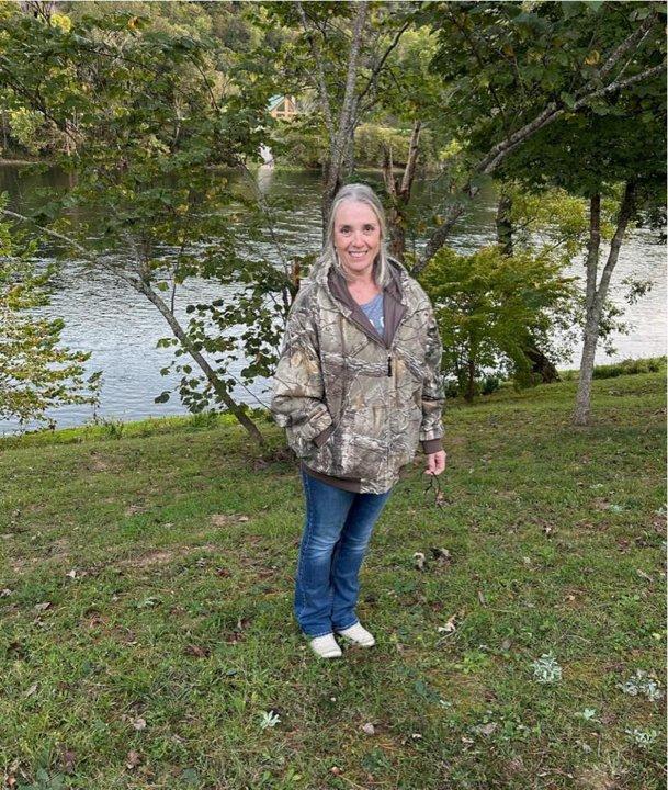 Woman standing in front of river on rural Oklahoma property – land clearing services