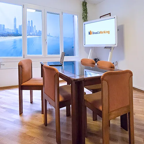 Gruppo di senior seduti in cerchio, ognuno con smartphone, istruttore che spiega con calma, ambiente luminoso e familiare, composizione 1:1