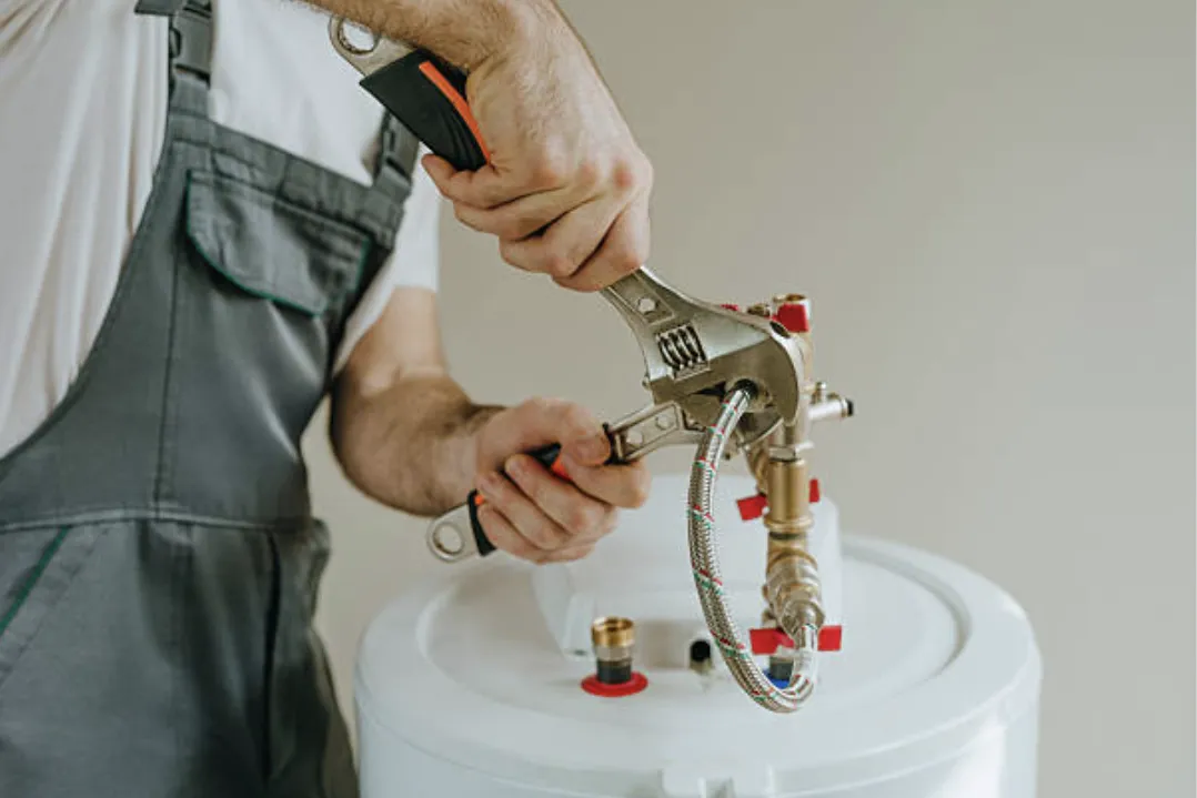 Plumber in Owasso repairing water heater pipes