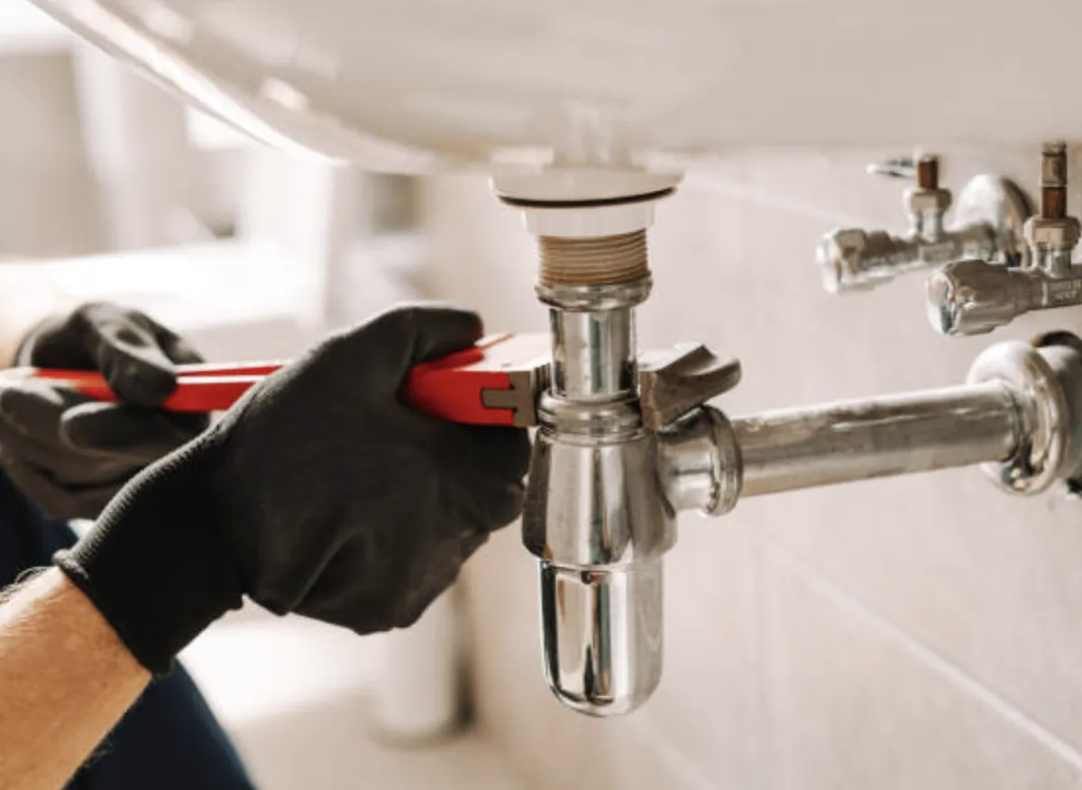 Owasso plumber tightening pipe with wrench