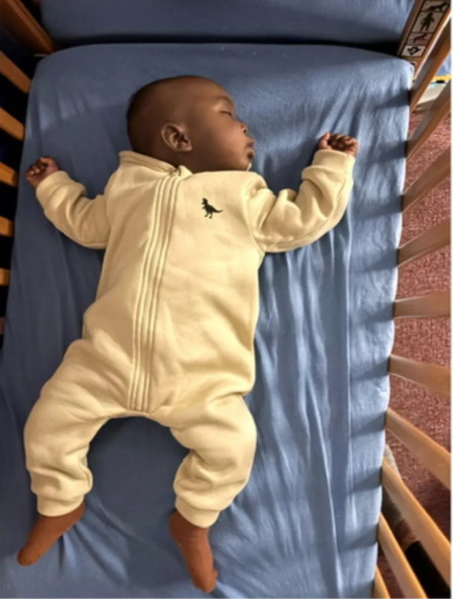 Boy sleeping in crib safely 