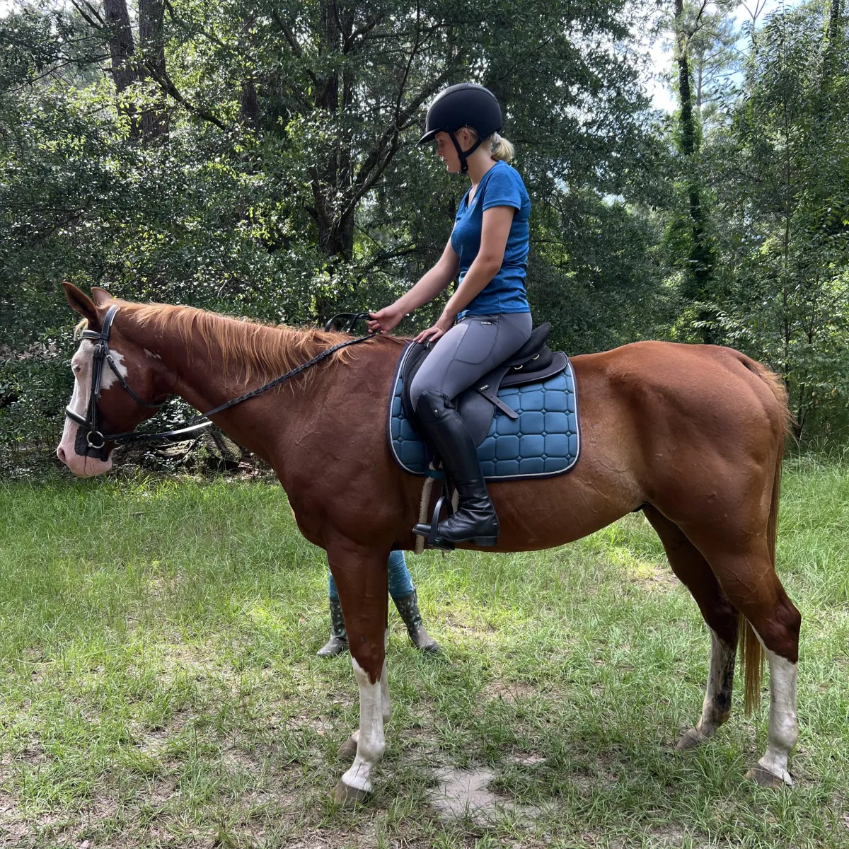 Girl is riding english on a trail ride 