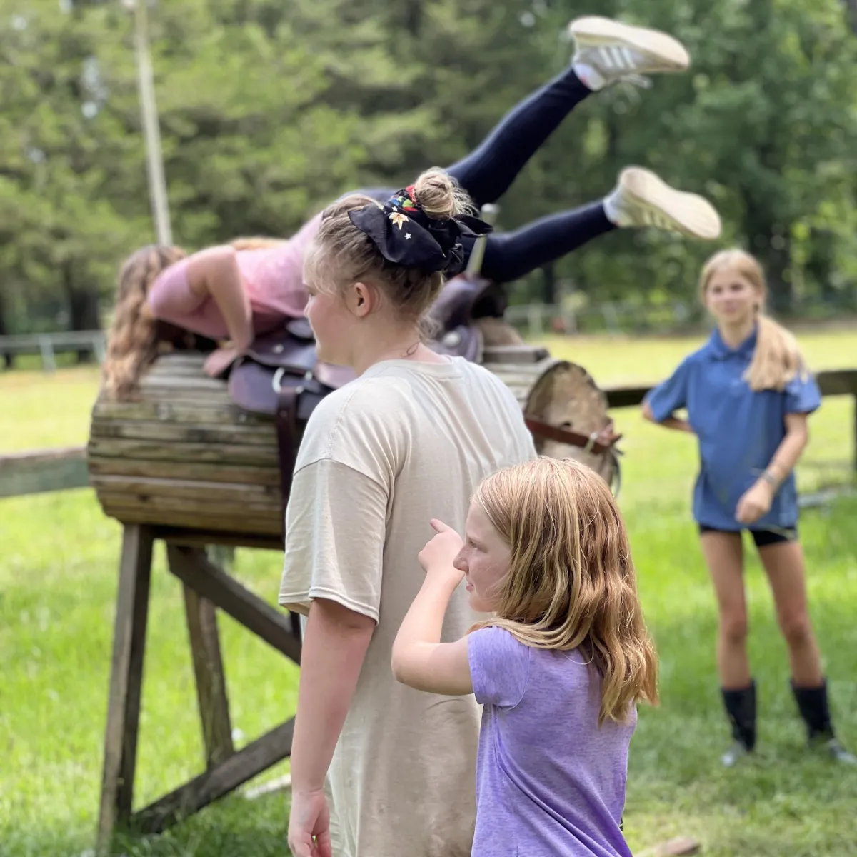 Campers participating in supervised horsemanship and confidence-building activity at horse camp