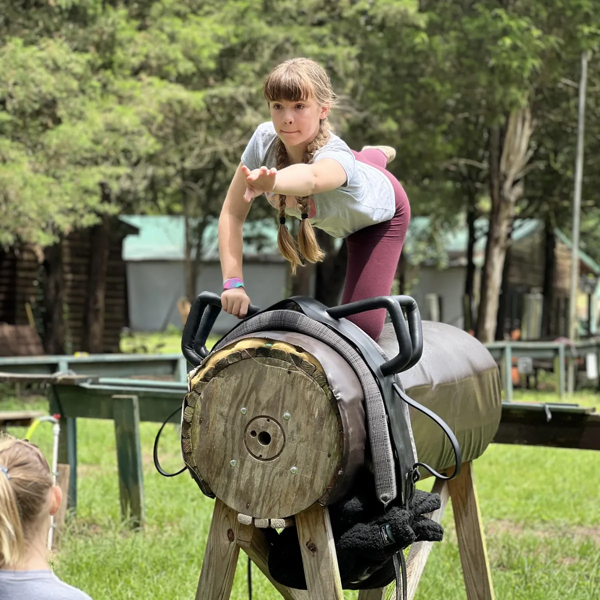 Child practicing balance and coordination on barrel training obstacle at Spring Break Horse Camp