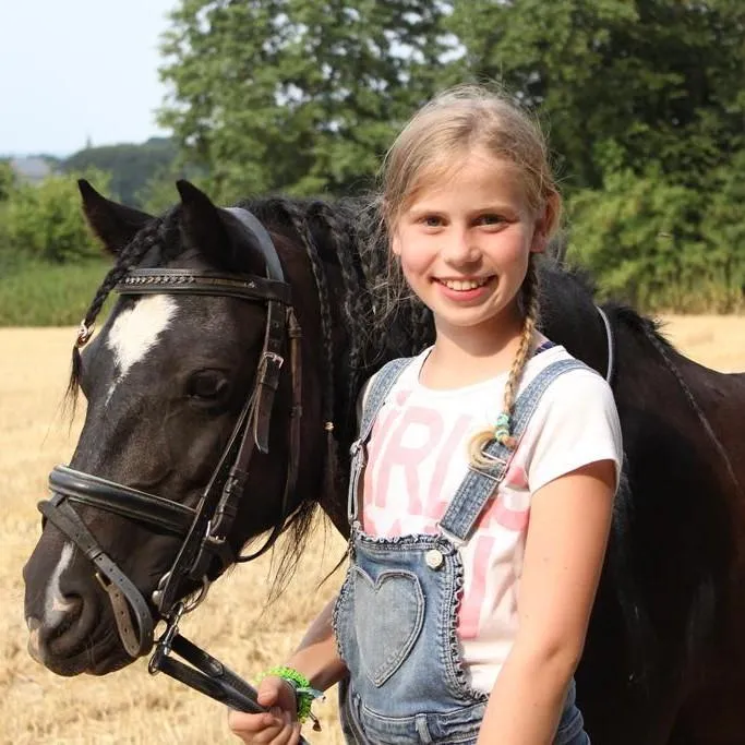 Girl holding pony at a pony camp 