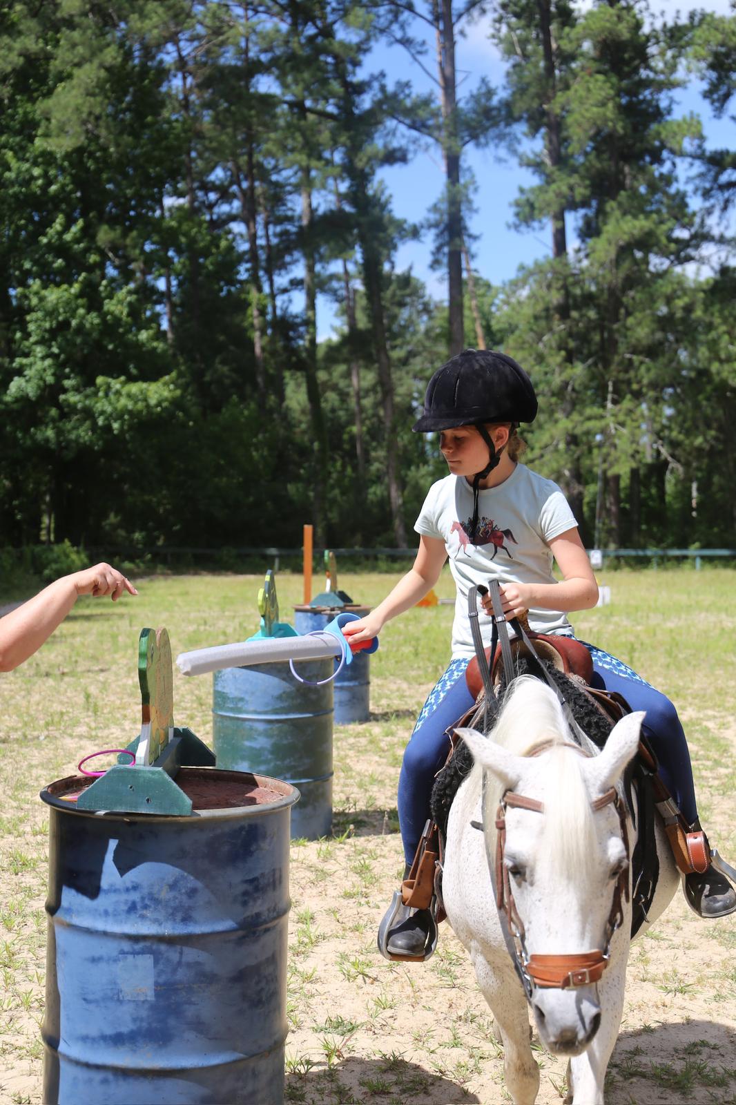 Young rider practicing control and balance during horsemanship activity at Spring Break Horse Camp in Hopkins SC