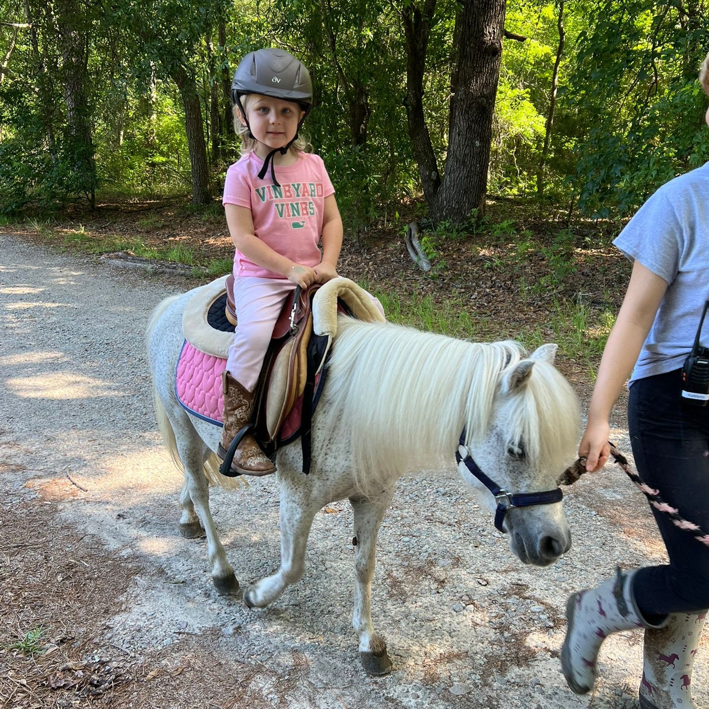 boy is learning to sit and balance on his pony 