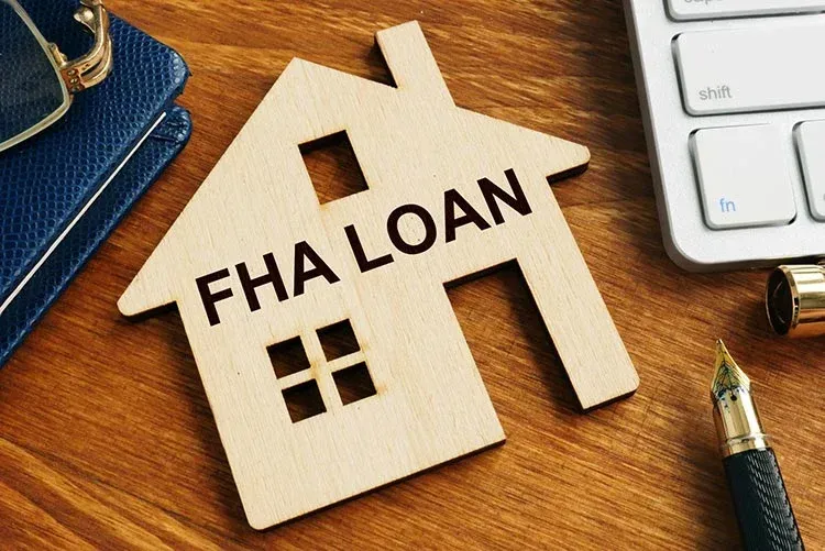 First-time homebuyer in front of a house purchased with an FHA loan and 3.5% down payment