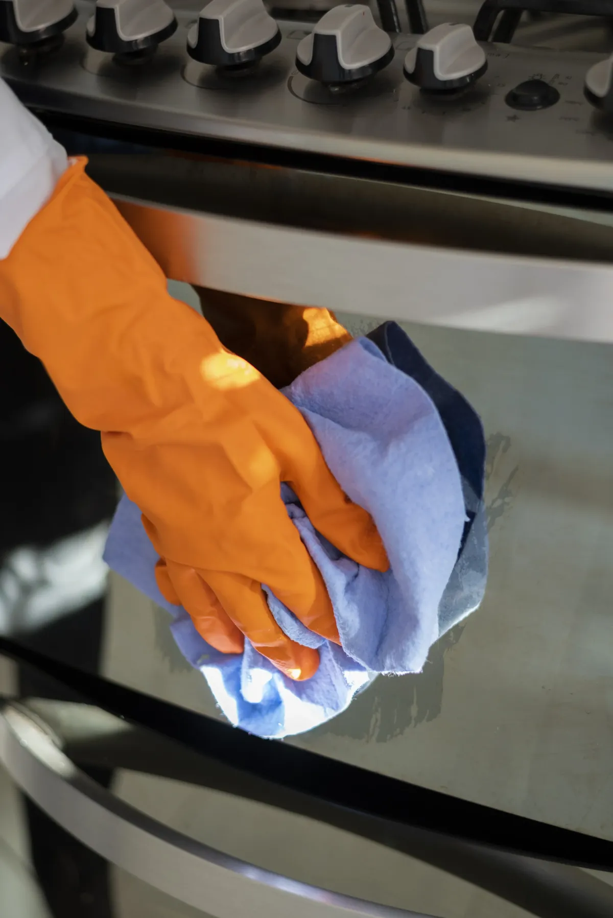 cleanerw wiping down a stove