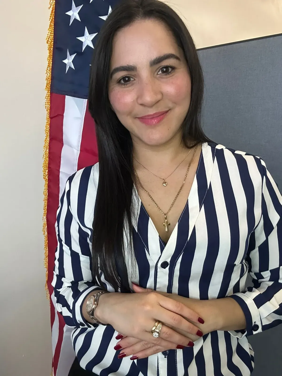 Dayana experta en immigration co na bandera de USA detrás de ella 