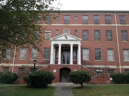 Exterior view of the historic red brick main building at the Crownsville Hospital Center in Crownsville, Maryland