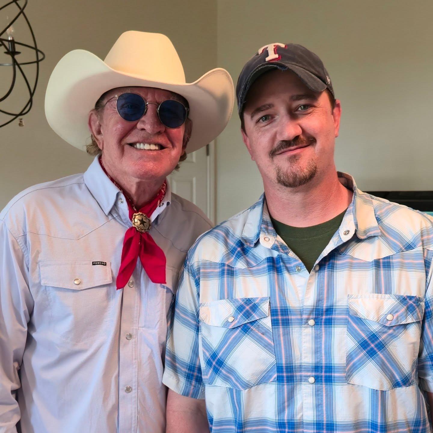 man carrying guitar near car