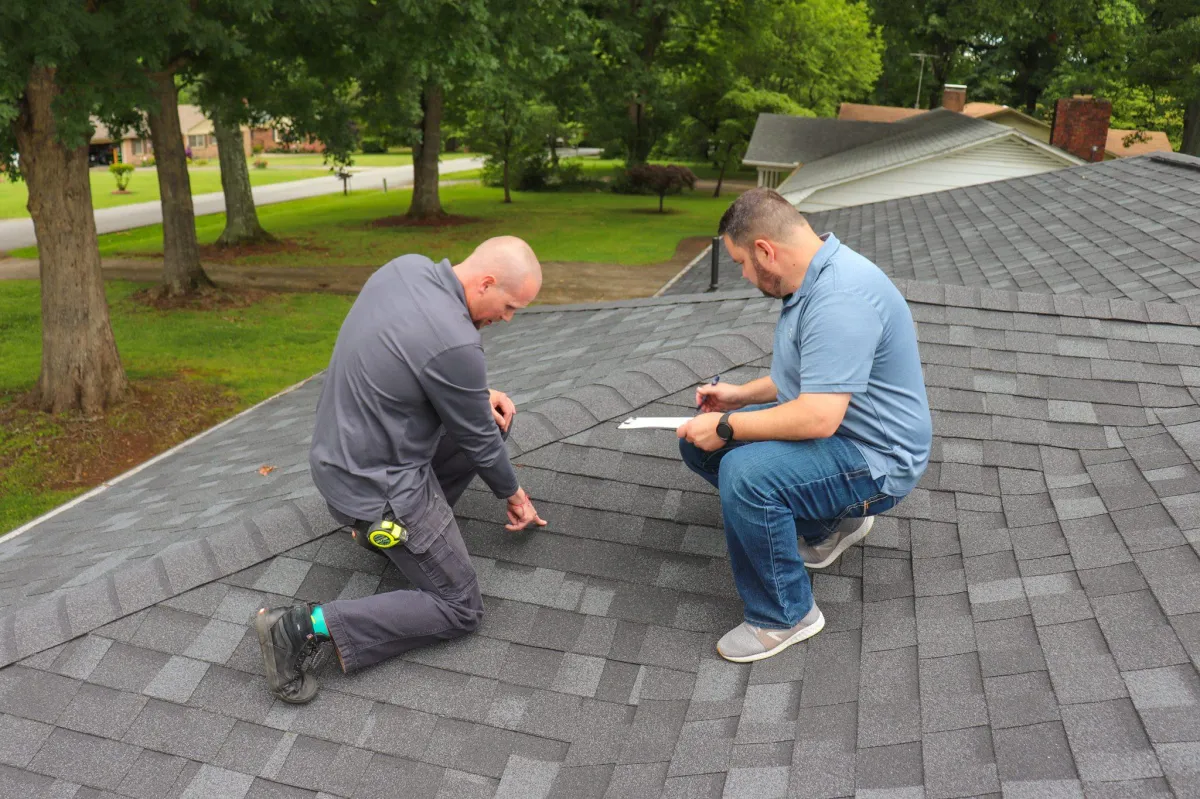two roofing technicians asses a roof 