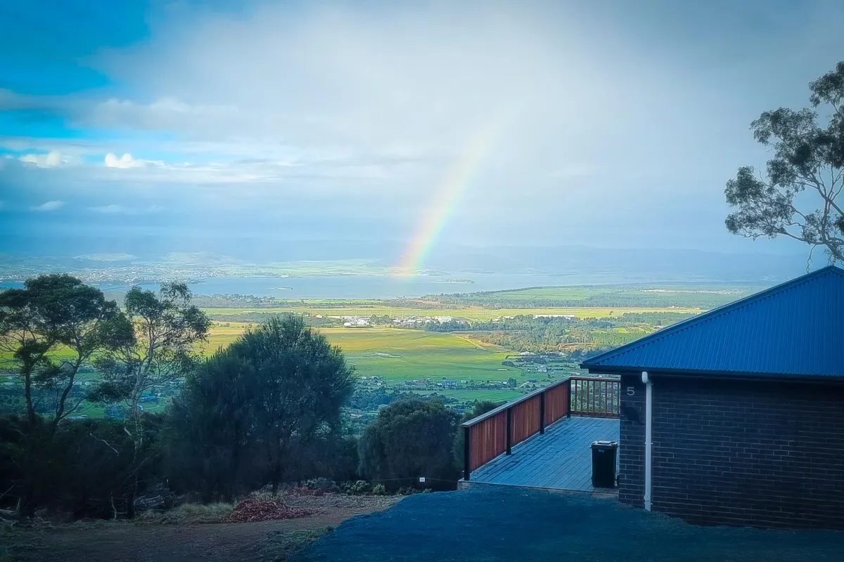 person at peak of mountain carrying red backpack