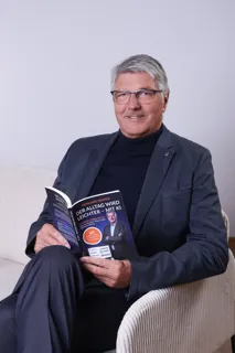 man in gray suit jacket holding white ipad