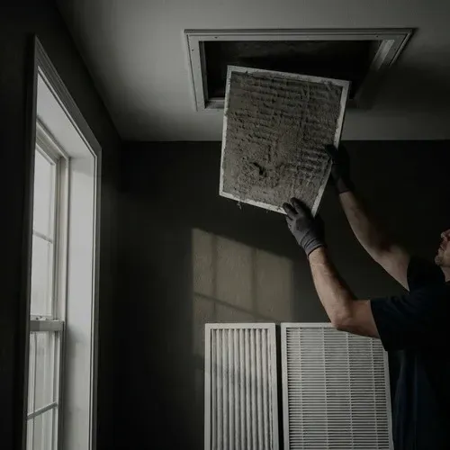Technician replacing a dirty indoor air filter with a clean one to improve home air quality.