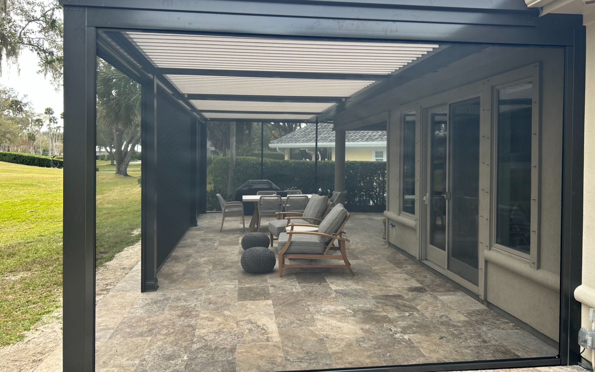 StruXure pergola with retractable screens fully enclosed outdoor room travertine floor Florida