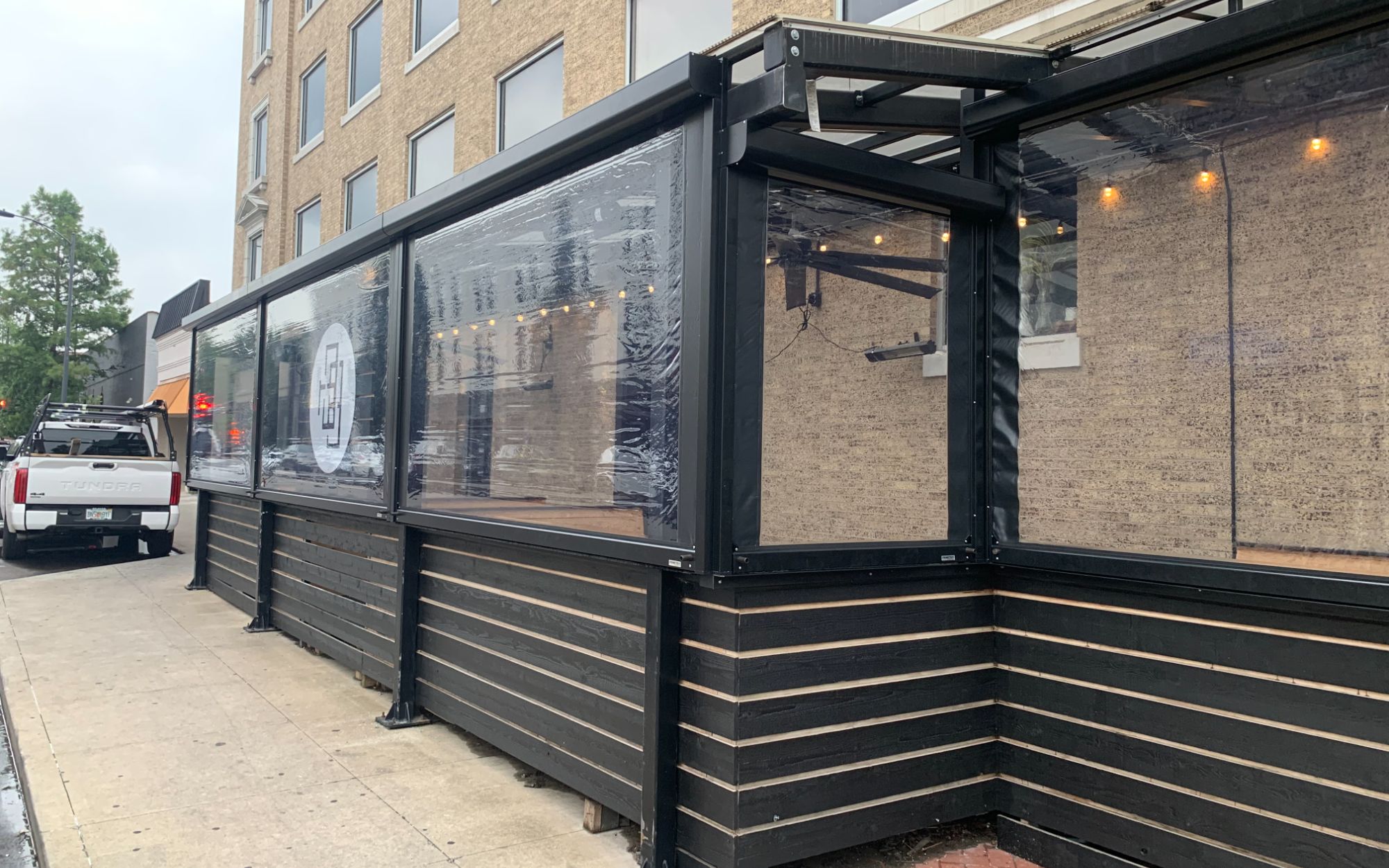 Modern dark frame StruXure pergola attached to multi-story building commercial installation Florida
